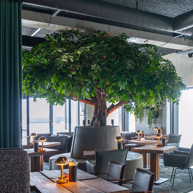 Stor kunstig plante i restaurant.